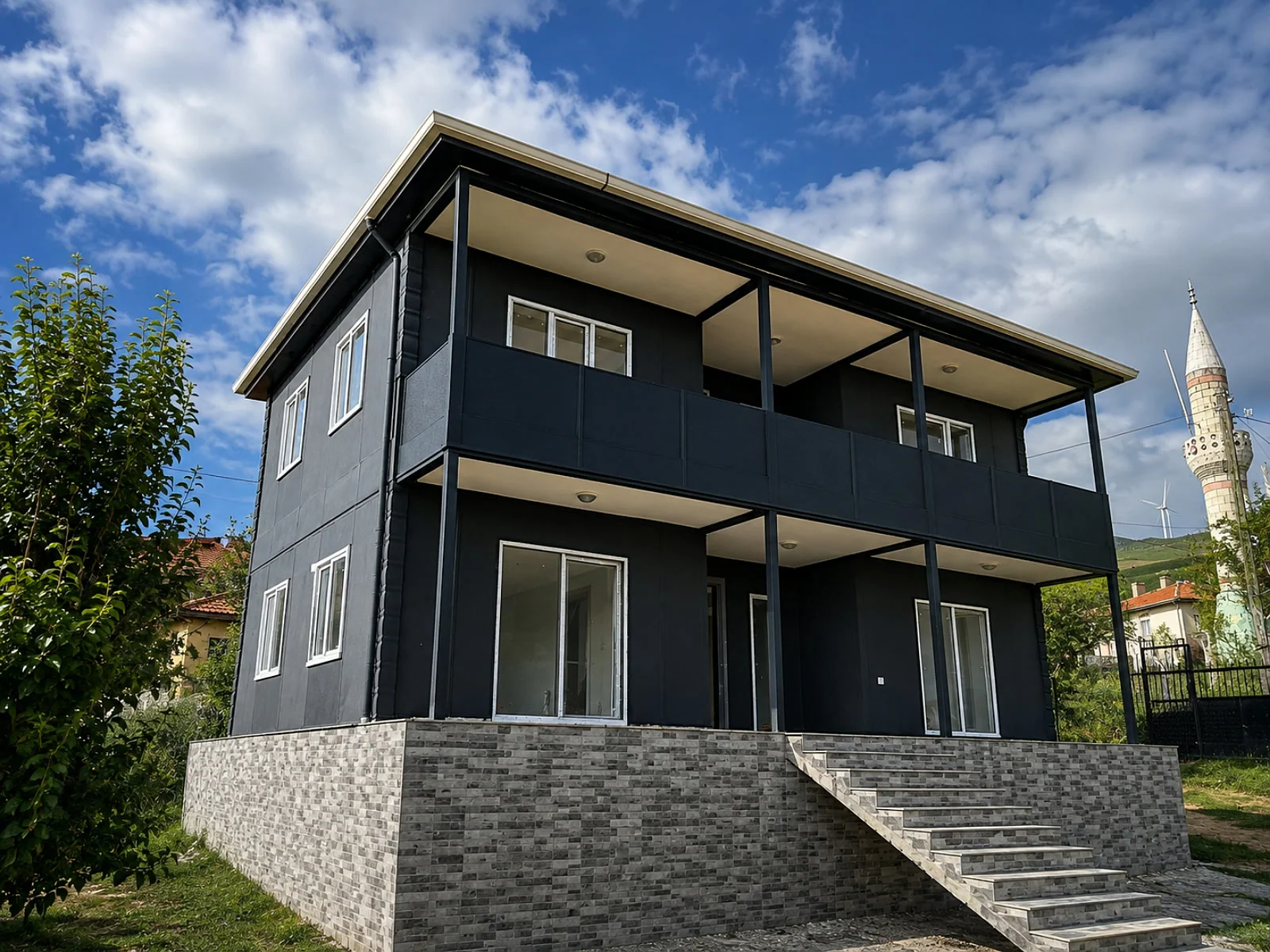 Çift katlı 3+1 prefabrik ev, antrasit cephe, geniş kapalı teras ve taş basamaklı giriş merdiveni