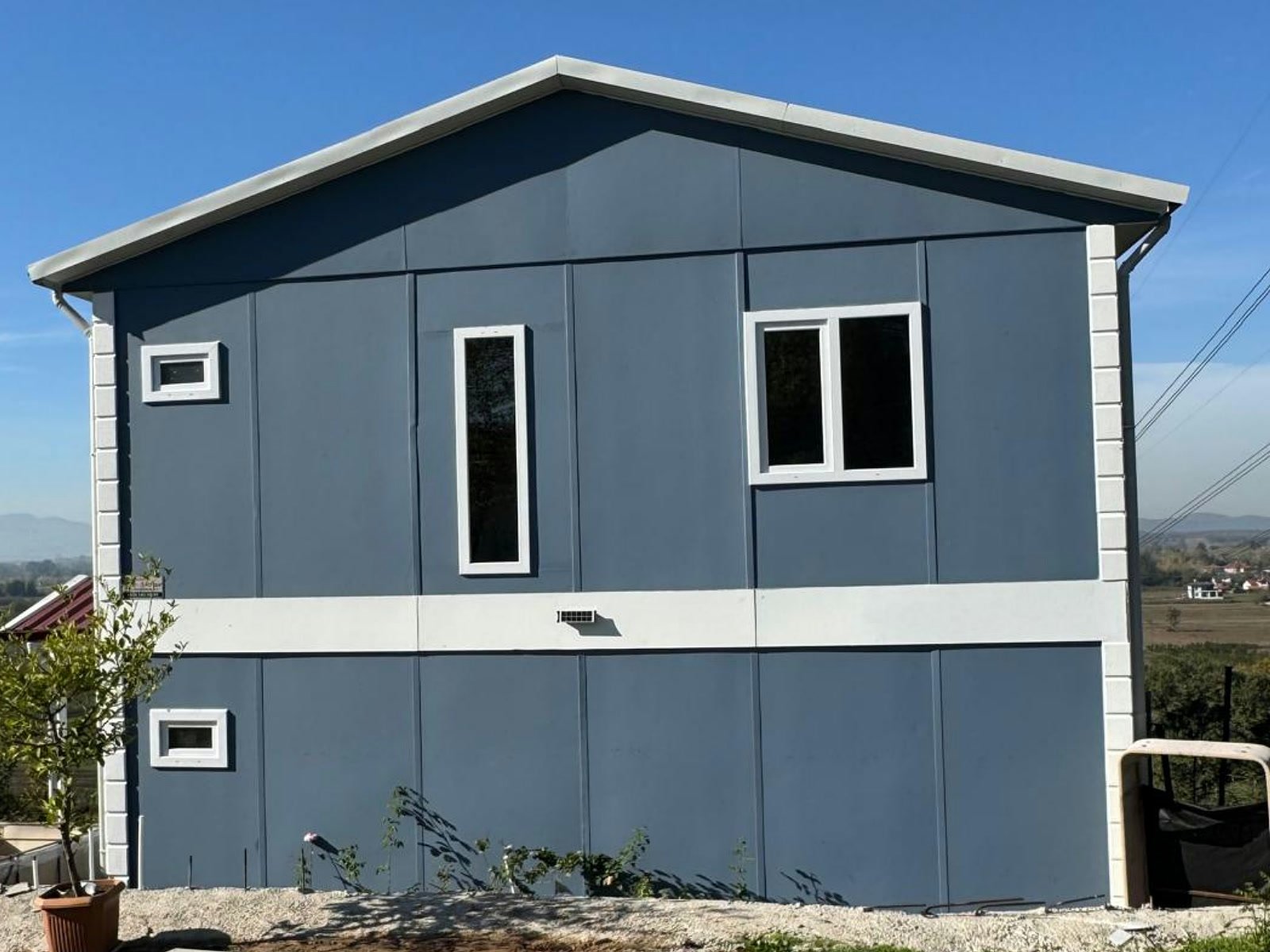 Çift katlı 3+1 prefabrik ev, mavi gri cephe ve sade alınlıklı dış görünüm