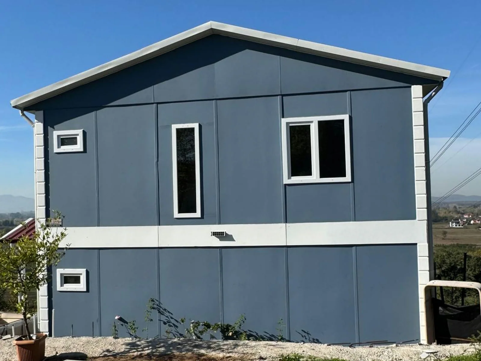 Çift katlı 3+1 prefabrik ev, mavi gri cephe ve sade alınlıklı dış görünüm